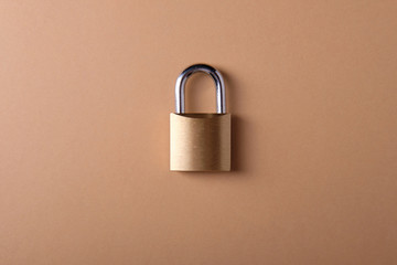 Small metal padlock on an orange background