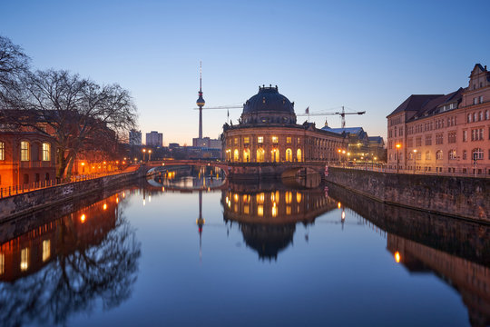 Berlin, Germany, Museum Island on Spree river and TV tower in the background at sunrise, Bode-Museum, cityscape early in the morning, reflections in the water, beautiful blue sky, dusk