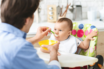Toddler eating healthy kid food at kitchen interior