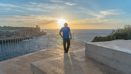 Hombre haciendo estiramientos al amanecer con teléfono móvil