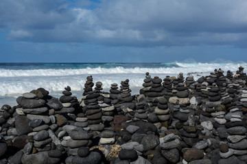 Stones pyramid on pebble beach symbolizing stability, zen, harmony, balance.