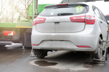 Tow truck lifting the car for improper parking. The utility service removes the wrongly parked car.Image can be used for topics like traffic offense.