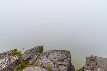 Rocks in the foreground and dense fog in the background