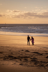 couple walking on the beach in Margate at sunset