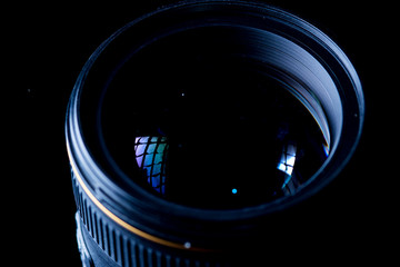 The camera lens photographed close-up on a dark background.