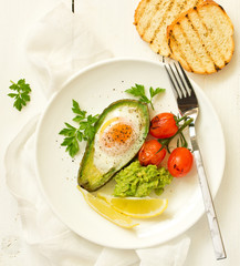 Fried eggs in avocado with guacamole sauce. Breakfast. Selective focus