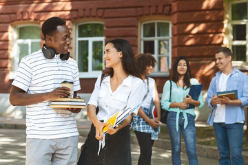 Student couple having break after study, talking and flirting outdoors