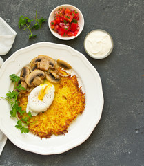 Potato pancake with poached egg, salad and mushrooms. Selective focus