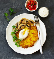 Potato pancake with poached egg, salad and mushrooms. Selective focus