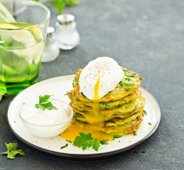 Fritters from zucchini and greens with poached egg. Healthy breakfast. Selective focus