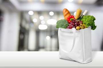 Full shopping bag with various vegetables on the desk