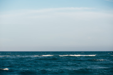 Blue sea with waves and cloudy sky background. Seascape background for design.