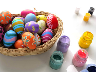Easter eggs on a beautiful variety of bamboo plates and bottles of various colors, isolated on a white background