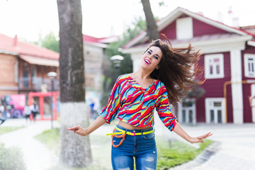 Happiness and craziness. Smiling funny girl have fun outdoor and dances. Young attractive woman with waving long hair playing in summer park.