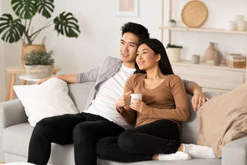 Fototapeta premium Korean couple resting at home and watching tv