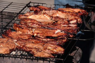 A large steak of grilled meat with smoke. Cooking in the open air.