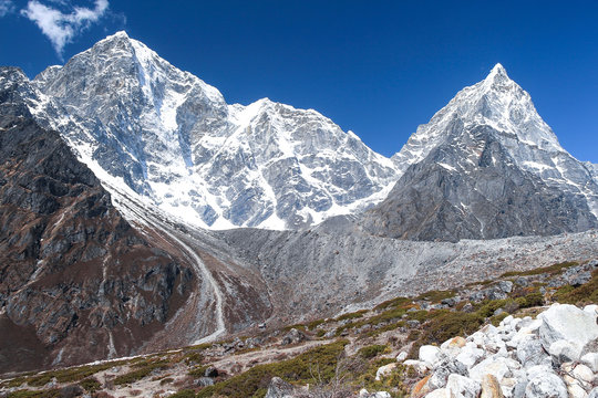 View of Tobuche (left) and Taboche (right) mountain peaks in Himalayas in the morning on the way to Everest base camp in Nepal. Clear blue sky. Theme of beautiful mountain landscapes.