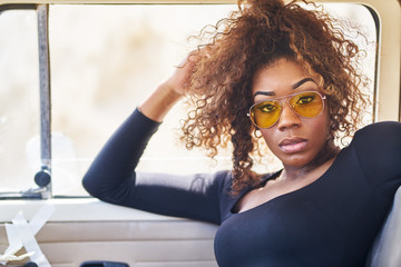 edgy african american model posing in vintage vehicle interior