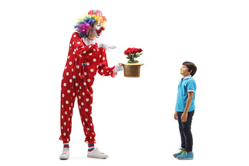 Clown performing a trick with flowers and hat in front of a boy