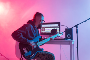 Obraz premium Professional musician recording guitar in digital studio at home, Music production technology concept.