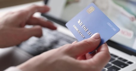 Female hands of cardholder holding credit card making e bank online payment. Woman consumer paying for purchase in web store using laptop technology. Ecommerce website payments concept. Close up view - Powered by Adobe