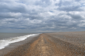 a sky of storm clouds on a lonely beach