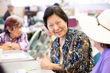 Smiling Asian Woman in a Senior Activity Center