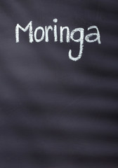 Obraz premium Moringa written with chalk on rustic background - Moringa oleifera