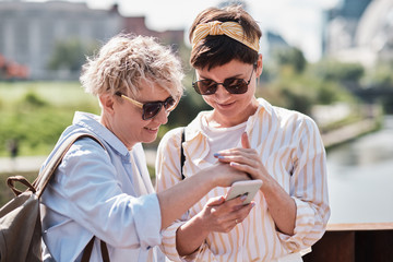 Two women using smart phone outdoor