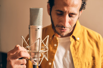 Bearded man recording vocals in studio