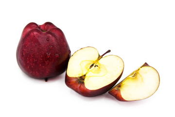 Red organic apple, half and quarter apple with water drops isolated on a white background.