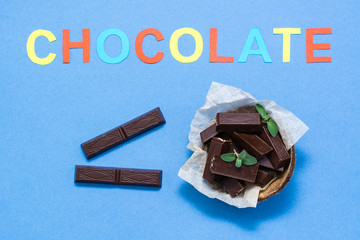 Chocolate pieces and mint leaves in a bowl and the inscription 