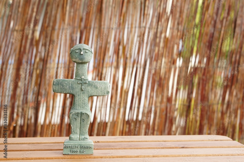 Poster Closeup shot of the Cyprus fertility symbol sculpture on a wooden table