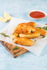 Homemade chicken nuggets on a wooden Board lie on a concrete background.