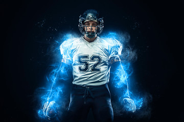 American football player in helmet with ball in hands. Fire background. Team sports. Sport...