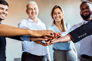 Cheerful Business People Holding Hands Standing In Circle In Office
