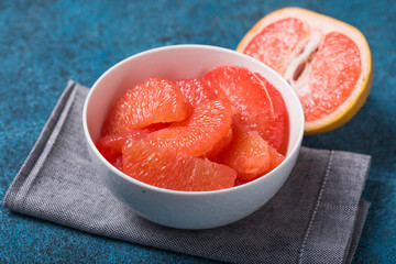 Fresh grapefruit slices in a wooden bowl, healthy snack