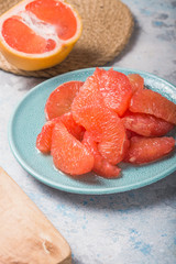 Fresh grapefruit slices in a wooden bowl, healthy snack