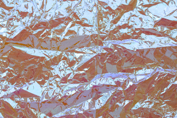 Photo of a real bright crumpled holographic background with texture in yellow toned with rays...