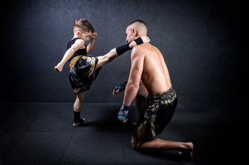 Kickboxing coach is training the boy. The concept of family, sports, mma, muay thai.