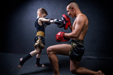 Kickboxing coach is training the boy. The concept of family, sports, mma, muay thai.