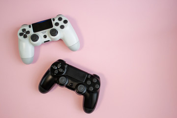 Black and white gamepads on pink background