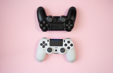 Black and white gamepads on pink background © amaidesign