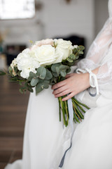 Bride holding in hands a wedding bouquet of pastel flowers, vintage style, blurred background