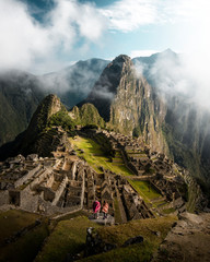 Young tourist couple are on vacation, with ponchos in Machu Picchu