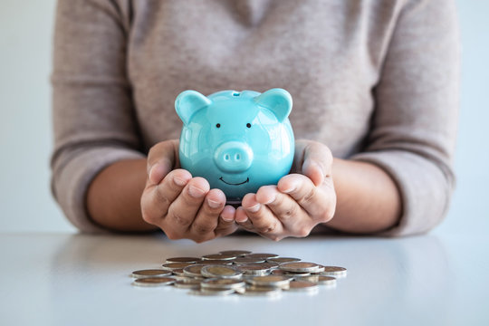 Young woman hands protection piggy bank and planning growing saving to strategy with pile coins for future plan fund of travel, education, home and retirement