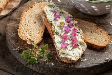 A slice of bread with herbal butter made from young nettles, with lungwort flowers