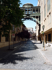 cobbled street with pedestrian bridge between buildings in Santiago, Chile