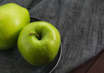 Two green apples on a gray background. Greeting card, place for your text. A symbol of a healthy lifestyle