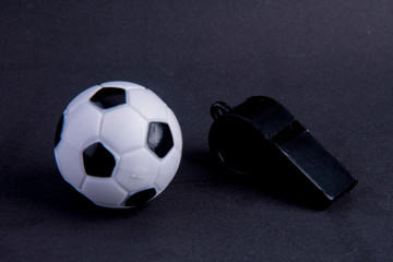 whistle with football on black background